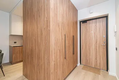a large wooden door in a room with a kitchen at #stayhere - New & Stylish Minimalistic 1BDR Vilnius City Center in Vilnius