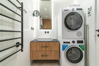 a washing machine and a washer and dryer in a bathroom at #stayhere - New & Stylish Minimalistic 1BDR Vilnius City Center in Vilnius