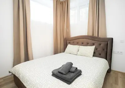 a bed with two towels sitting on top of it at Central Station Apartment No2 in Kaunas
