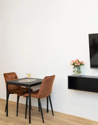 a black table with two chairs and a tv on a wall at Central Station Apartment No3 in Kaunas