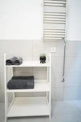 a white shelf in a bathroom with a shower at Central Station Apartment No3 in Kaunas