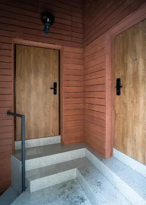 two wooden doors on a wooden wall with stairs at Central Station Apartment No3 in Kaunas