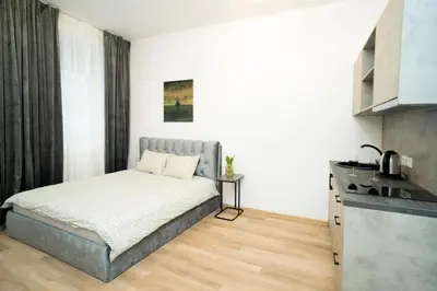 a bedroom with a bed and a kitchen at Central Station Apartment No3 in Kaunas