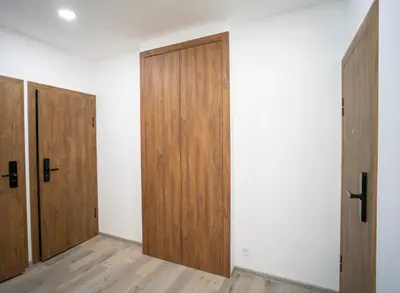 an empty room with wooden doors and wooden floors at Central Station Apartment No6 in Kaunas