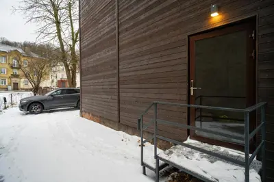 a car parked next to a building in the snow at Central Station Apartment No6 in Kaunas
