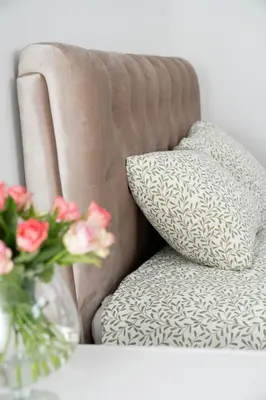 a couch with a pillow and a vase of flowers at Central Station Apartment No6 in Kaunas