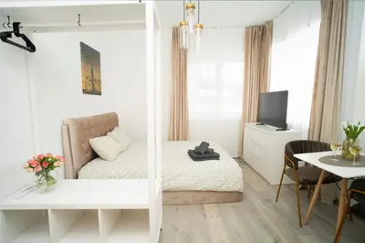 a bedroom with a bed and a table and a tv at Central Station Apartment No6 in Kaunas
