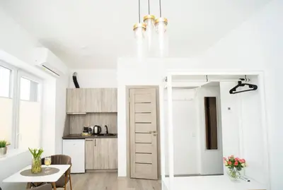 a white kitchen with a table and a dining room at Central Station Apartment No6 in Kaunas