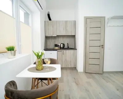 a kitchen and dining room with a table and chairs at Central Station Apartment No6 in Kaunas