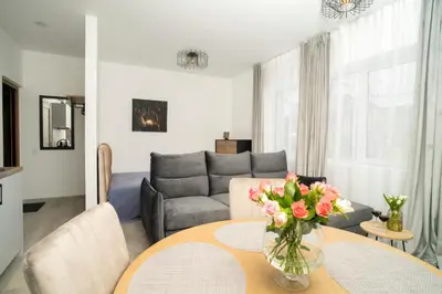 a living room with a couch and a table with flowers at Central Station Apartment No7 in Kaunas