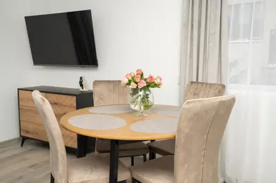 a dining room table with a vase of flowers on it at Central Station Apartment No7 in Kaunas