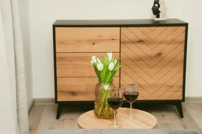 a table with two glasses of wine and a vase of flowers at Central Station Apartment No7 in Kaunas