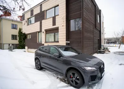 a car parked in the snow in front of a house at Central Station Apartment No7 in Kaunas