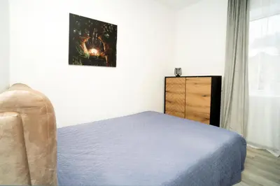 a bedroom with a blue bed and a dresser at Central Station Apartment No7 in Kaunas