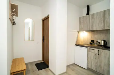 a kitchen with white walls and wooden cabinets at Central Station Apartment No8 in Kaunas