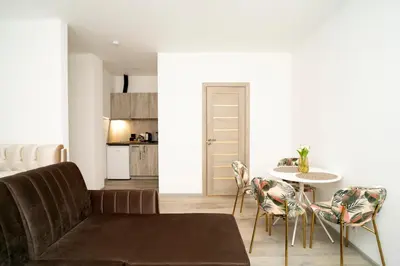 a living room with a couch and a table and chairs at Central Station Apartment No8 in Kaunas