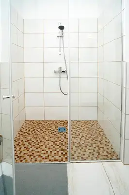 a shower with a glass door in a bathroom at Central Station Apartment No8 in Kaunas