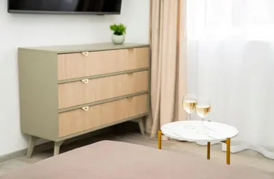 a bedroom with a dresser and two glasses of wine at Central Station Apartment No8 in Kaunas
