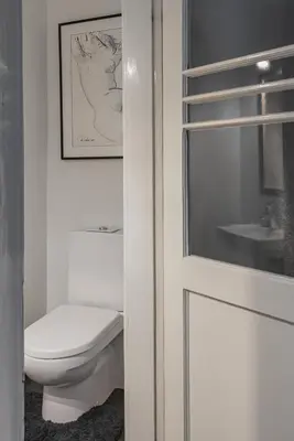 a white bathroom with a toilet and a sink at Apt-Gallery in Central Kaunas in Kaunas