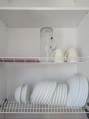 a row of plates and eggs on a shelf in a refrigerator at Maironio apartamentai in Radviliškis