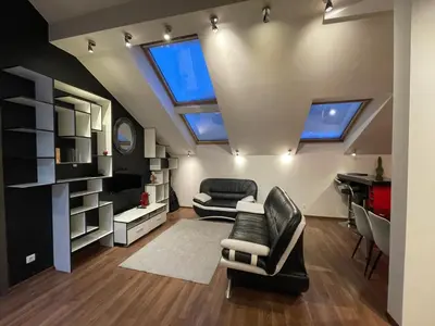a living room with skylights and a couch and chairs at Apartamentai prie Seimo in Vilnius