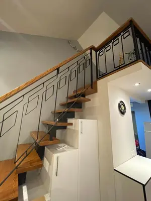 a staircase in a house with a white refrigerator at Apartamentai prie Seimo in Vilnius