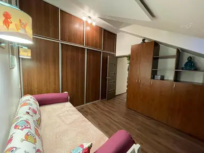 a living room with a couch and wooden cabinets at Apartamentai prie Seimo in Vilnius