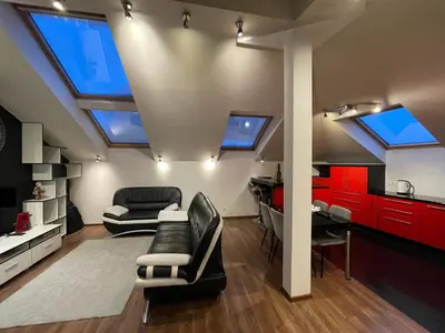 a living room with red cabinets and a black couch at Apartamentai prie Seimo in Vilnius