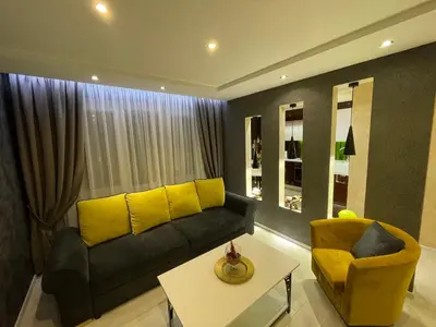 a living room with a black couch and yellow pillows at Apartment in Šiauliai in Šiauliai