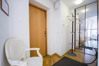 a room with a white chair and a door at Historic Central Apartment in Vilnius