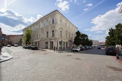 a large building on a city street with cars parked at Historic Central Apartment in Vilnius