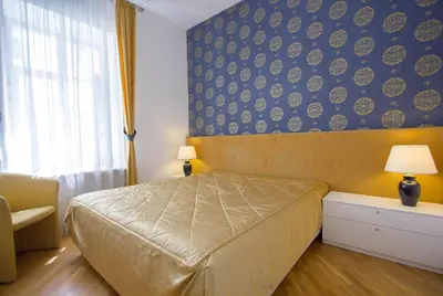 a bedroom with a bed and a blue wall at Historic Central Apartment in Vilnius
