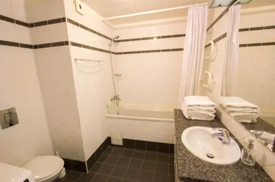 a bathroom with a sink and a toilet and a tub at Historic Central Apartment in Vilnius