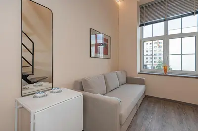 a living room with a couch and a mirror at Modern loft apartment near Christ's Resurrection Church by Polo apartments in Kaunas