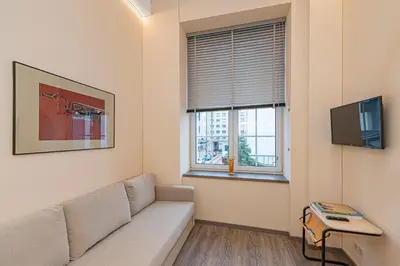 a living room with a couch and a tv at Modern loft apartment near Christ's Resurrection Church by Polo apartments in Kaunas