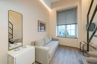 a living room with a couch and a mirror at Modern loft apartment near Christ's Resurrection Church by Polo apartments in Kaunas