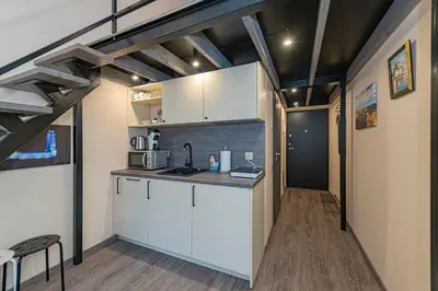 a kitchen with white cabinets in a room at Modern loft apartment near Christ's Resurrection Church by Polo apartments in Kaunas