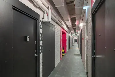 a corridor of a building with a row of stalls at Modern loft apartment near Christ's Resurrection Church by Polo apartments in Kaunas