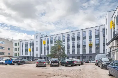 a parking lot with cars parked in front of a building at Modern loft apartment near Christ's Resurrection Church by Polo apartments in Kaunas