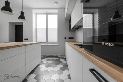 a kitchen with white cabinets and a black and white floor at Stylish apartment in city center in Vilnius