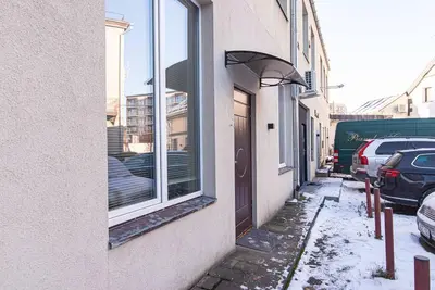 a window on a building with snow on the sidewalk at Stylish apartment in city center in Vilnius