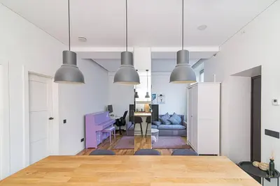 a dining room and living room with pendant lights at Stylish apartment in city center in Vilnius