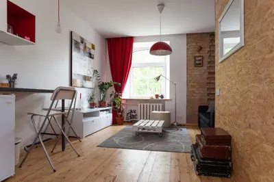 a living room with a table and a chair at #stayhere - Stylish Studio Close to Old Town in Vilnius