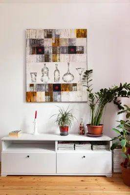 a white dresser in a living room with plants at #stayhere - Stylish Studio Close to Old Town in Vilnius