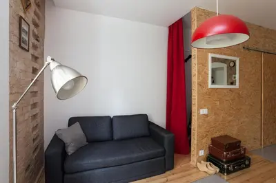 a living room with a black couch and a red lamp at #stayhere - Stylish Studio Close to Old Town in Vilnius