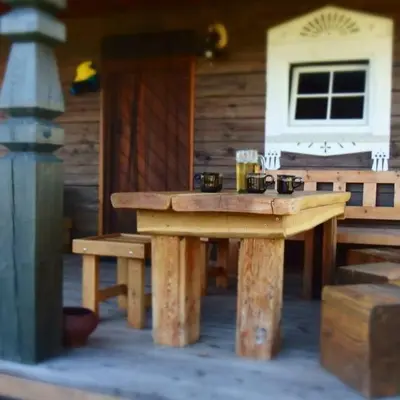 a wooden picnic table in front of a cabin at Barškulių Sodyba in Ricieliai