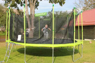 two people are playing on a trampoline at Barškulių Sodyba in Ricieliai