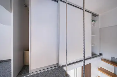 a walk in closet with glass doors at Kauno Mini Loft by Lollo Stay in Vilnius