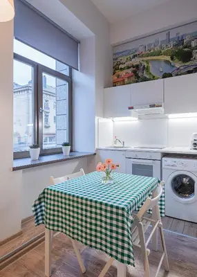 a kitchen with a table with a checkered table cloth at Kauno Mini Loft by Lollo Stay in Vilnius