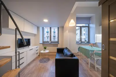 a living room with a couch and a table at Kauno Mini Loft by Lollo Stay in Vilnius
